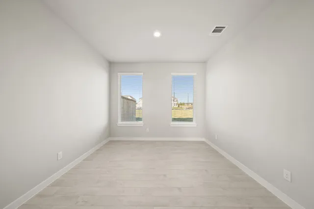 a view of an empty room with chandelier fan