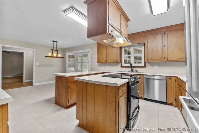 a kitchen with stainless steel appliances granite countertop a sink a stove and a refrigerator