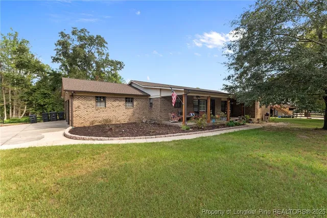 a view of a house with backyard and sitting area
