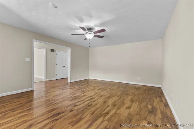 a view of an empty room with wooden floor