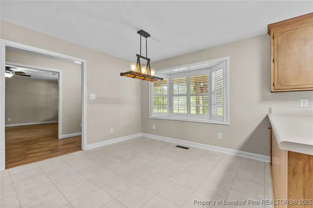 a view of an empty room with window and cabinet