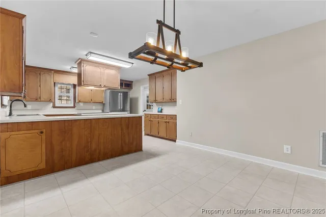 a kitchen with stainless steel appliances granite countertop a sink a stove top oven and cabinets