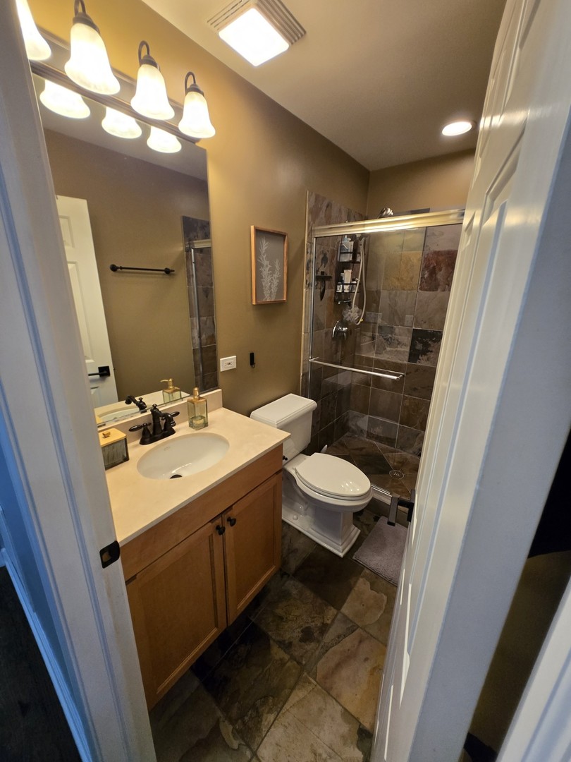 1915 South State Street, Unit 3 Chicago, IL 60616 - Photo 14 of 29 a bathroom with a sink and mirror with toilet