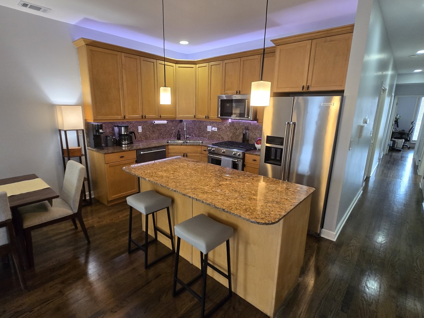 1915 South State Street, Unit 3 Chicago, IL 60616 - Photo 5 of 29 a kitchen with stainless steel appliances granite countertop sink refrigerator dining table and chairs