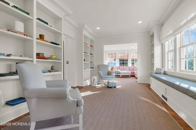 a view of a hallway with wooden floor and windows