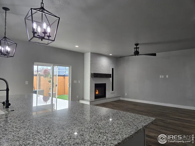 an empty room with windows and fireplace