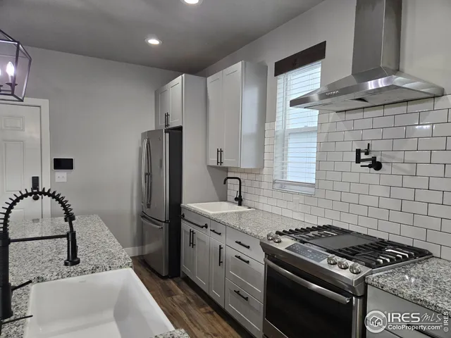 a kitchen with stainless steel appliances granite countertop a sink stove and refrigerator