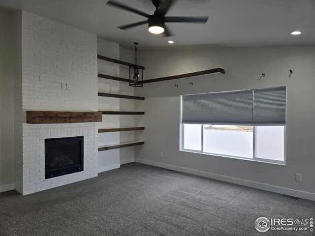 an empty room with a fireplace and fan