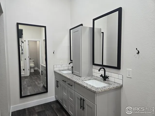 a bathroom with a granite countertop sink and a mirror