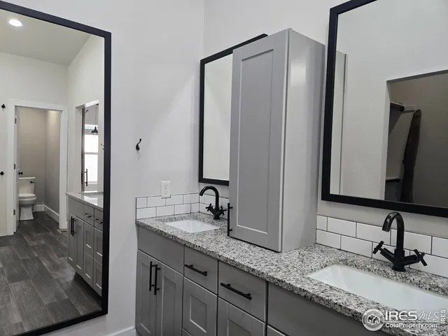 a bathroom with a granite countertop sink and a mirror