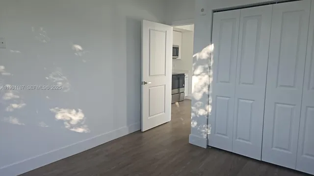 a view of empty room with wooden floor