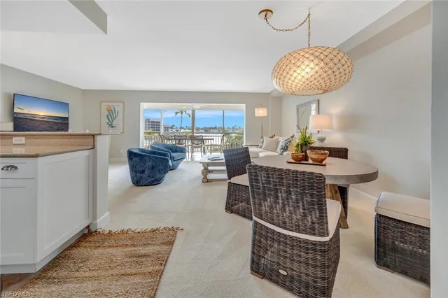 a living room with furniture a dining table and a chandelier