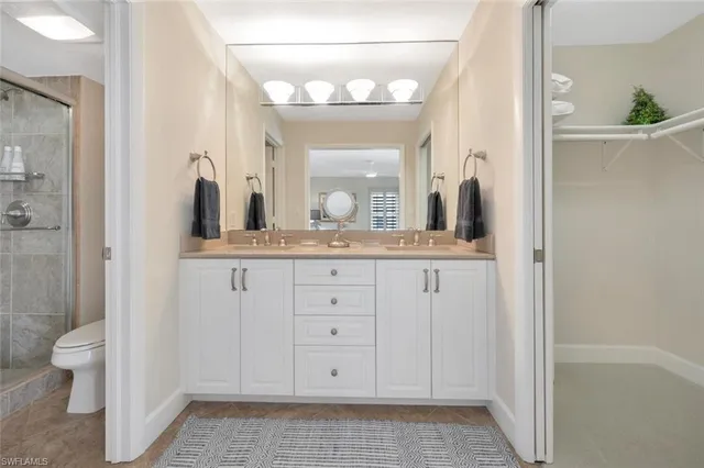 a bathroom with a granite countertop sink a toilet and a mirror