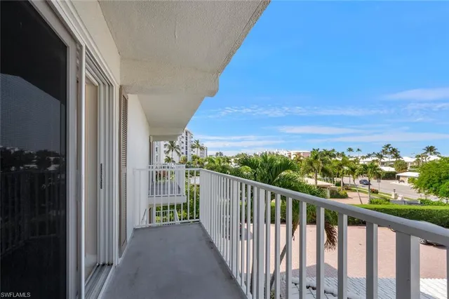 a view of a swimming pool with a lawn chairs under an umbrella