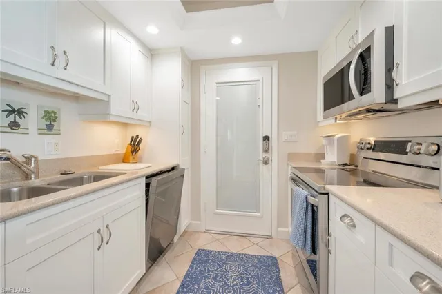 a kitchen with a sink dishwasher stove and cabinets