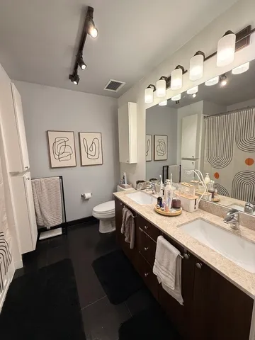 a spacious bathroom with a double vanity sink and a mirror