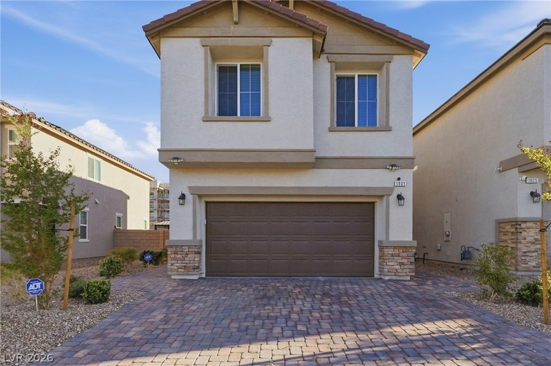 1921 Miller Ridge Avenue North Las Vegas, NV 89031 - Photo 4 of 26 This two-story residence features a charming stucco exterior with stone accents and a paver driveway.