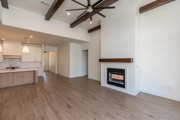 a view of an empty room with a fireplace and a window