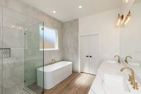 a bathroom with a tub a sink and mirror