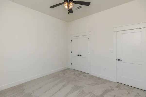 a view of a room with a chandelier fan