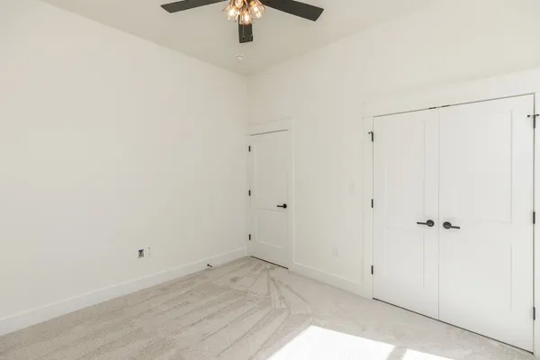 an empty room with a ceiling fan and a window