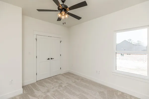 an empty room with a window and a fan