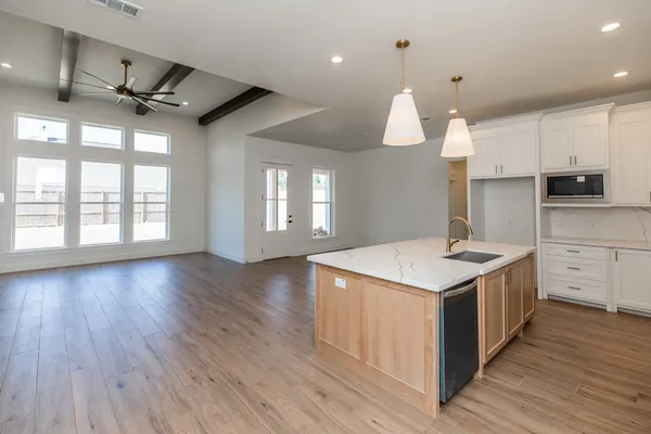 a kitchen with a stove a sink and wooden floor