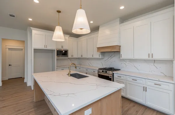 a kitchen with kitchen island a stove a sink a center island and cabinets