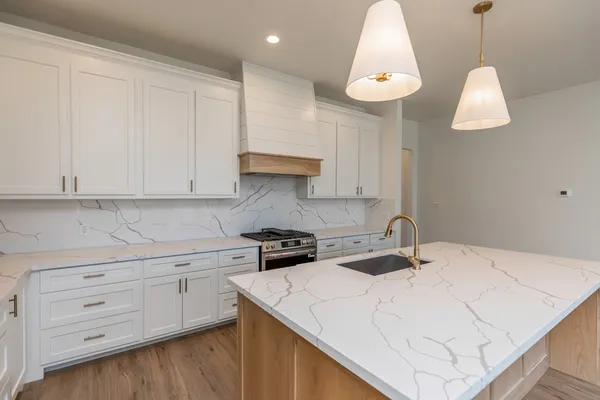a kitchen with a white cabinets and chandelier