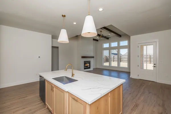 a kitchen with a sink a stove and wooden floor