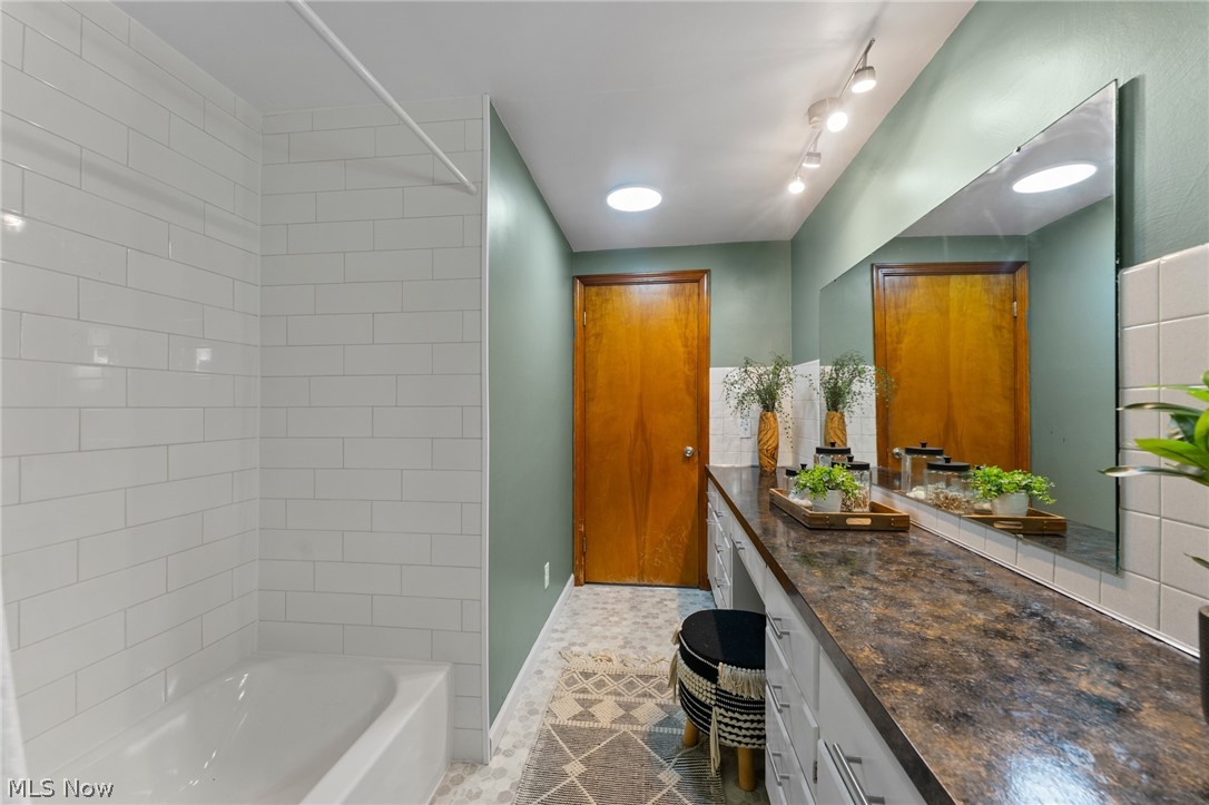3568 McCartney Road Youngstown, OH 44505 - Photo 18 of 29 Bathroom featuring tile floors, shower / washtub combination, track lighting, and large vanity