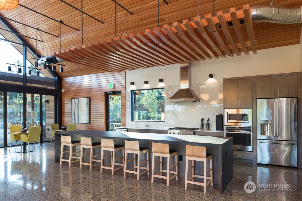 2740 Arrowroot Street Southeast Lacey, WA 98513 - Photo 12 of 15 a kitchen with stainless steel appliances granite countertop a stove a refrigerator a dining table and chairs with wooden floor