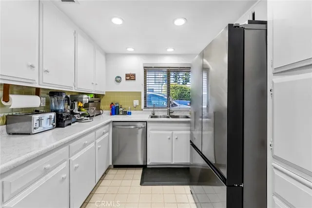 a kitchen with stainless steel appliances granite countertop a refrigerator and a sink