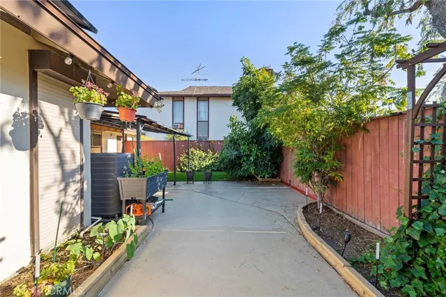 a view of a patio with table and chairs potted plants and wooden fence