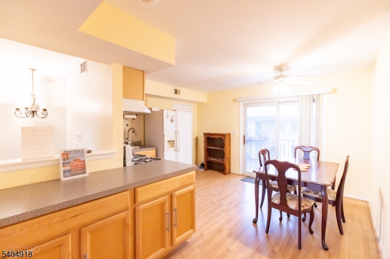 187 Evergreen Road Edison, NJ 08837 - Photo 3 of 8 a dining hall with stainless steel appliances kitchen island granite countertop a table chairs and a refrigerator