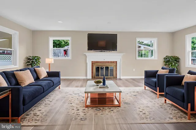 a living room with furniture a flat screen tv and a fireplace
