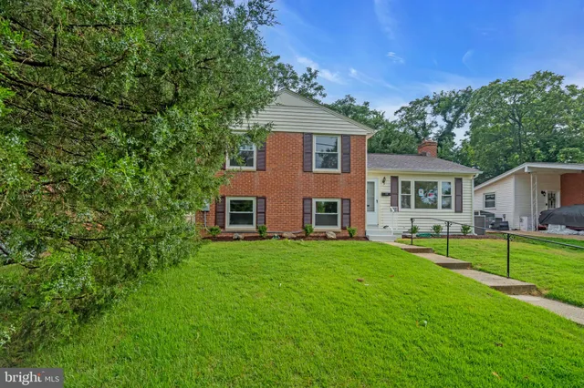 a front view of a house with a yard and trees