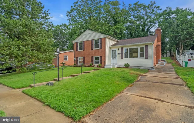 a front view of a house with a yard and trees