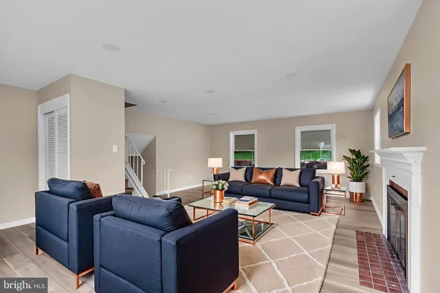 a living room with furniture a fireplace and a window