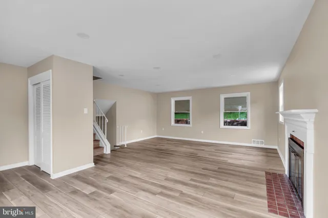 a view of empty room with wooden floor and fireplace