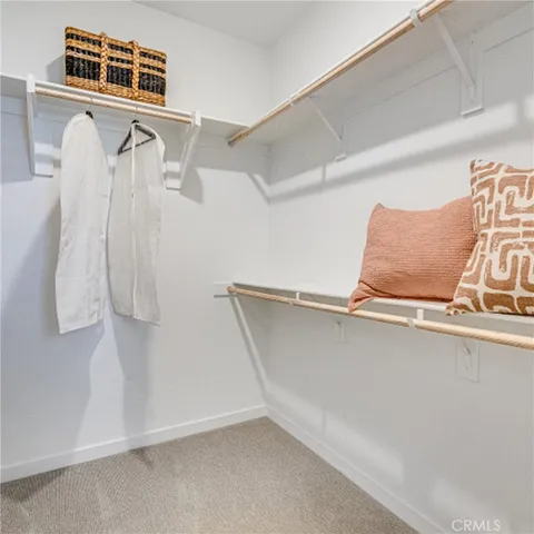 a view of walk in closet with clothes