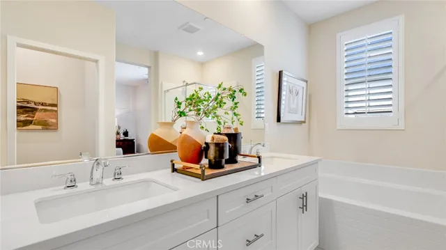 a bathroom with a double vanity sink window and flower pot