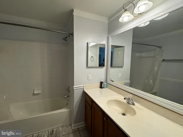 a bathroom with a tub sink vanity granite and mirror