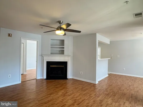 a view of an empty room with a fireplace and a window