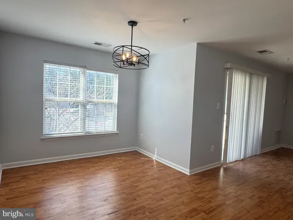 an empty room with wooden floor and window