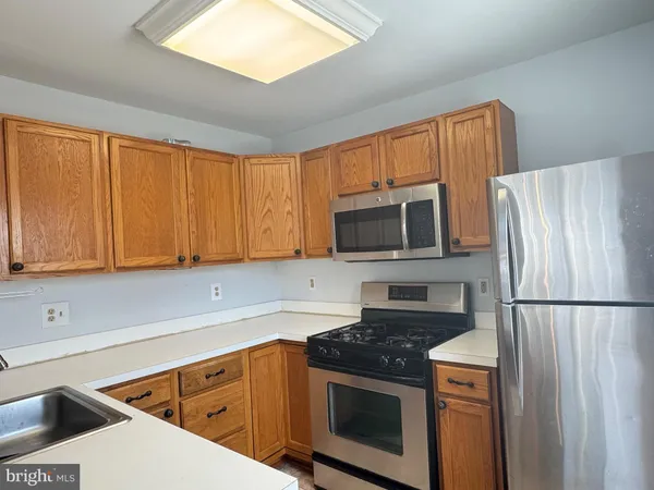 a kitchen with stainless steel appliances granite countertop a refrigerator stove and microwave