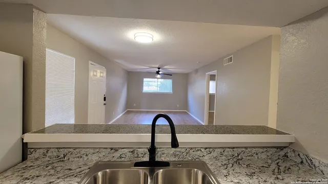 a view of a kitchen with a sink and entryway