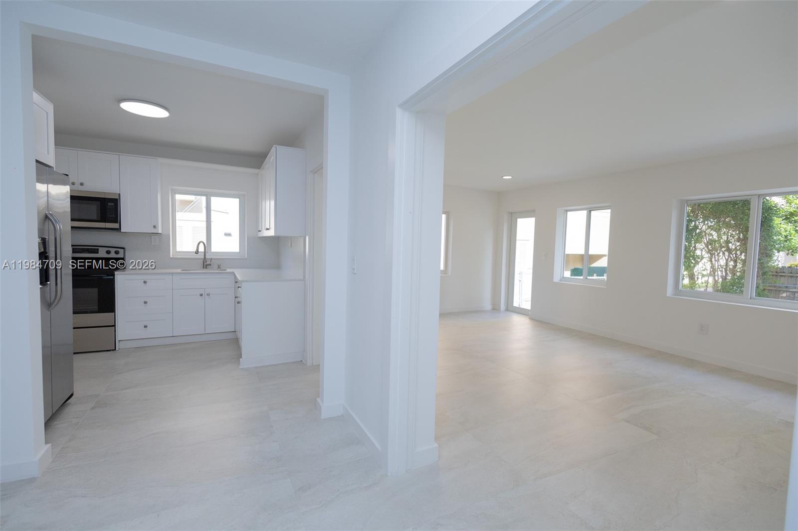 2675 Southwest 24th Terrace Miami, FL 33145 - Photo 7 of 36 an empty room with windows and kitchen view