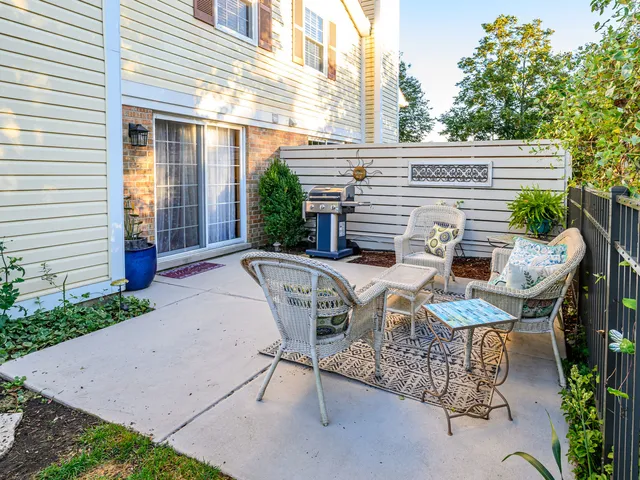 a view of a patio with table and chairs with wooden fence