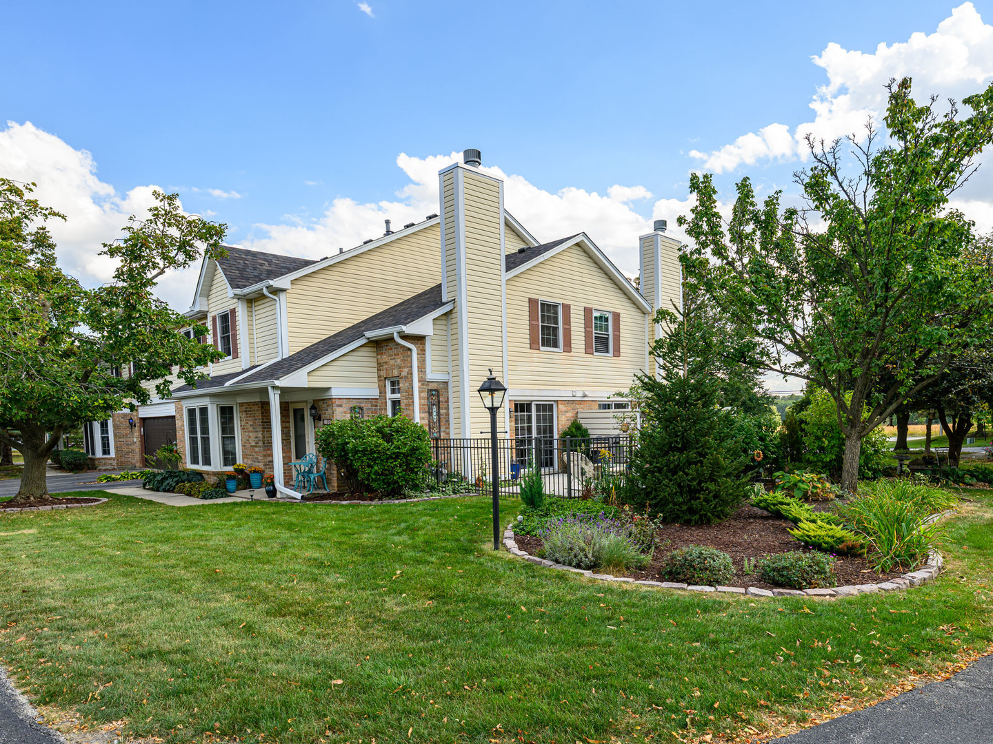 10111 Cambridge Drive, Unit COURTG Mokena, IL 60448 - Photo 30 of 31 a front view of a house with a yard table and chairs